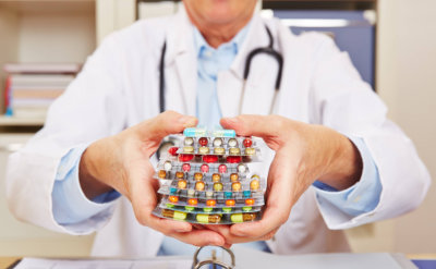 doctor holding many different colorful pills